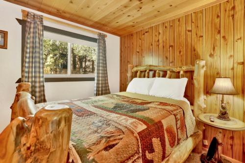 a log cabin bedroom with a bed and a window at Holmes Away From Home #2485 in Sugarloaf