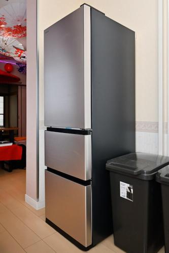 a stainless steel refrigerator next to a trash can at Otter Stay - Nagoya Castle in Nagoya