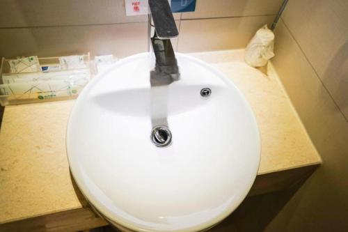 a bathroom sink with a knife on top of it at City Comfort Inn Wuhan High Speed Railway Station in Wuhan