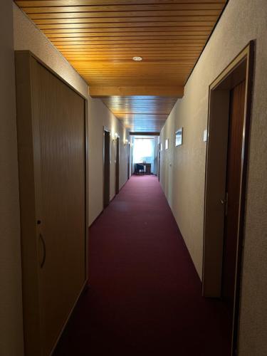 a hallway of an office building with a long red corridor at Stube Hotel und Gasthaus in Nordrach