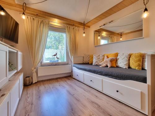 a room with a bed with a window and a tv at Mien lüttes Glück -Fewo Backboord in Zempin