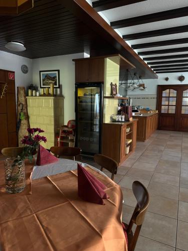 a kitchen with a table and a kitchen with a refrigerator at Stube Hotel und Gasthaus in Nordrach