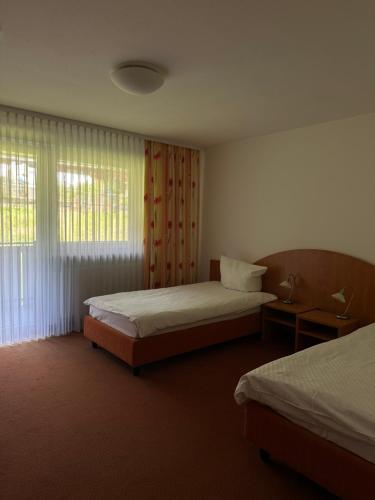 a hotel room with two beds and a window at Stube Hotel und Gasthaus in Nordrach