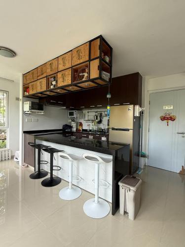 a kitchen with a black counter and two stools at City Oasis Guesthouse in Hong Kong
