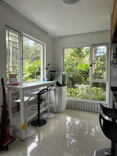 a white room with a desk and two windows at City Oasis Guesthouse in Hong Kong