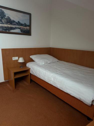 a bedroom with two beds and a table with a lamp at Stube Hotel und Gasthaus in Nordrach