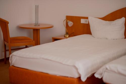a bedroom with a bed and a chair and a table at Stube Hotel und Gasthaus in Nordrach