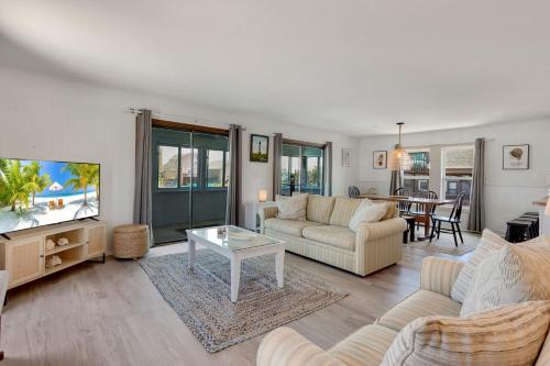 a living room with a couch and a tv at 4122 - Blue White Haven in Kitty Hawk