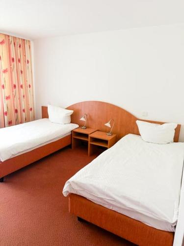 a hotel room with two beds and a table at Stube Hotel und Gasthaus in Nordrach