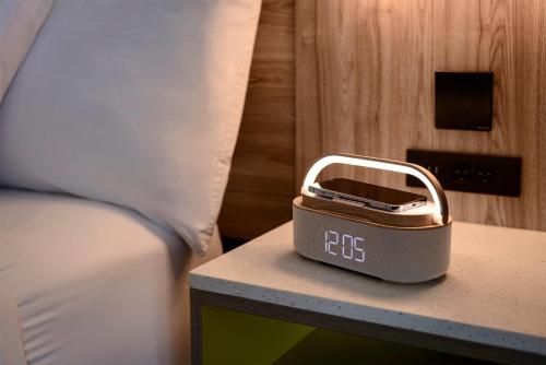 a alarm clock sitting on a table next to a bed at La Quinta by Wyndham Lexington Park - Patuxent in California