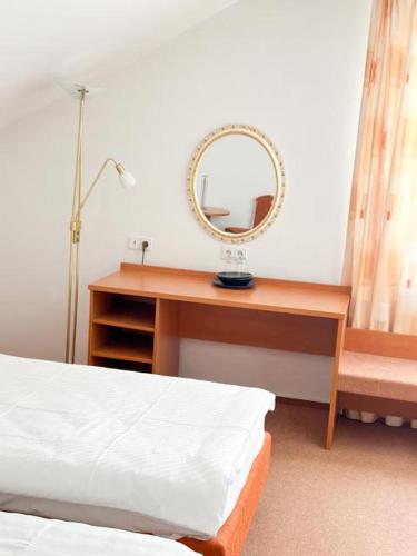 a bedroom with a desk with a mirror and a bed at Stube Hotel und Gasthaus in Nordrach