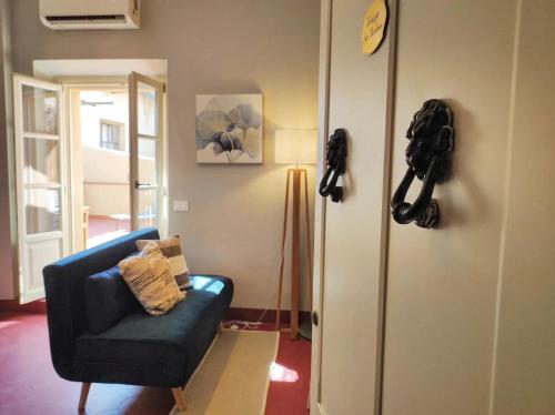 a living room with a blue chair and a phone on the wall at Terrazza San Martino San Gimignano Apartments in San Gimignano