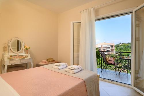 una camera da letto con un letto e un balcone con vista di Nostalgia Corfu Town Apartments a Città di Corfù