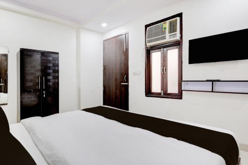a white bedroom with a bed and a window at FabHotel DD Green Residency in New Delhi