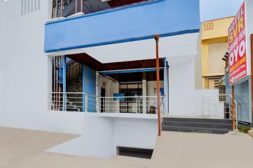 a white building with a blue awning at Hotel O SVR Grand Inn in Surūrnagar