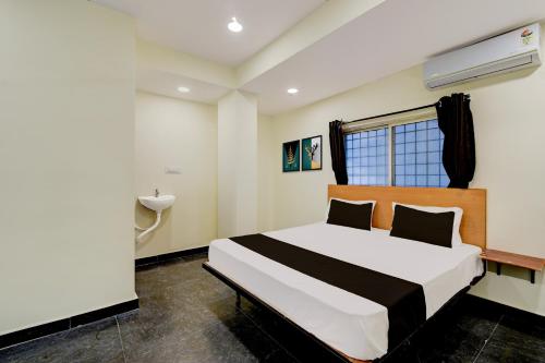 a bedroom with a bed and a sink at Hotel O SVR Grand Inn in Surūrnagar