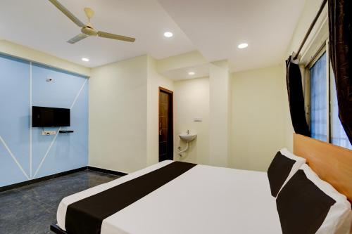a bedroom with a large bed and a tv at Hotel O SVR Grand Inn in Surūrnagar
