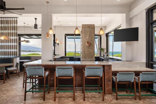a kitchen with a large wooden table and chairs at Hampton Inn & Suites Maui North Shore in Kahului