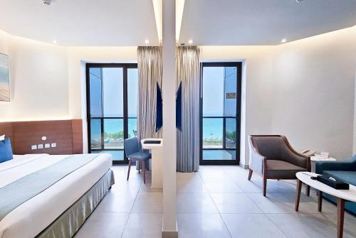 a hotel room with a bed and a desk and chairs at Wyndham Garden Ajman Corniche in Ajman 