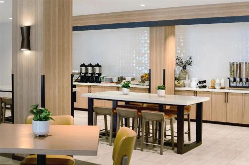 a restaurant with tables and chairs and a kitchen at Hilton Garden Inn LAX Los Angeles Airport in Los Angeles
