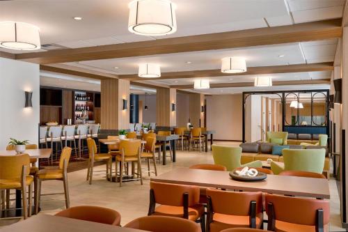 a restaurant with tables and chairs and a bar at Hilton Garden Inn LAX Los Angeles Airport in Los Angeles