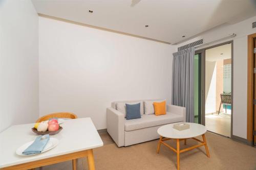 a living room with a couch and a table at Wyndham Garden Phuket Kamala in Kamala Beach