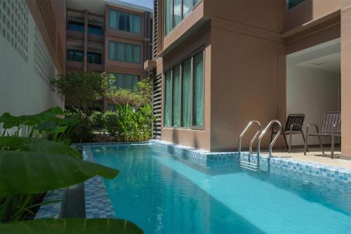a swimming pool in front of a building at Wyndham Garden Phuket Kamala in Kamala Beach