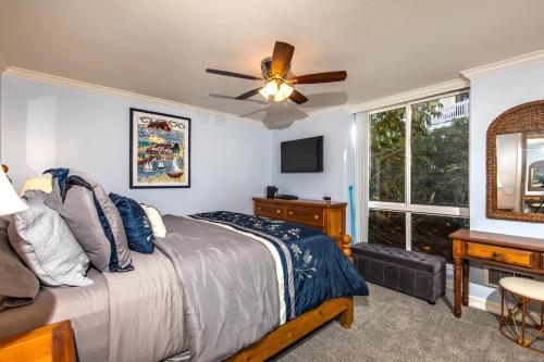 una camera da letto con un letto con un ventilatore a soffitto e una finestra di Oceanside Beach Condos a Oceanside