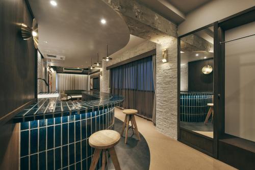 a bar in a restaurant with blue tile and stools at illi Lay Shibuya-Ebisu in Tokyo