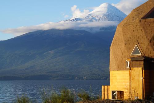 a mountain in the distance with a building and a mountain at Cabañas Domos May-Ling in Ensenada