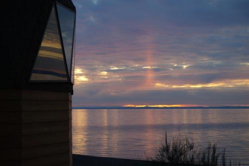 a view of the ocean at sunset from a house at Cabañas Domos May-Ling in Ensenada