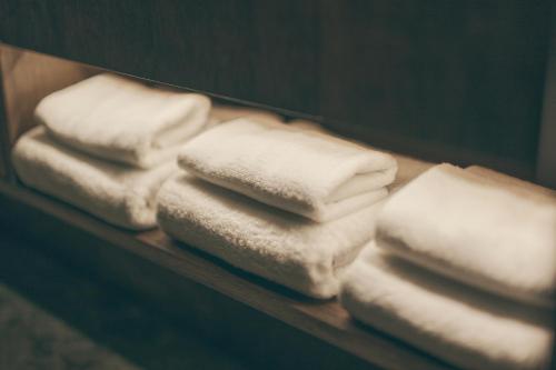 a pile of white towels on a shelf at illi Lay Shibuya-Ebisu in Tokyo