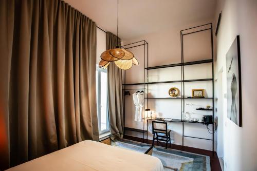 a bedroom with a bed and a desk and a window at Palazzo Piccinno in Parabita