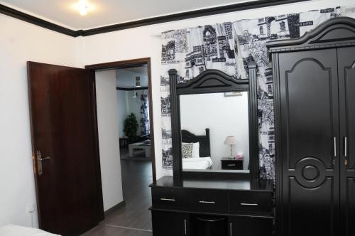 a bedroom with a dresser and a mirror at Arinza Tower Quality Apartments in Kuwait