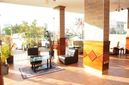 a lobby with chairs and a table in a building at Arinza Tower Quality Apartments in Kuwait