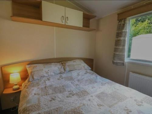 a bedroom with a bed and a window at Caravan 3 - Blackmoor farm near Tenby in Ludchurch