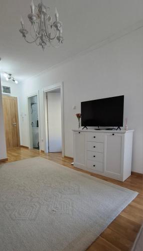 a living room with a television on a white dresser at Eleon in Petrovaradin