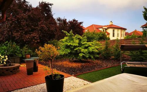 a garden with a house in the background at M3 green Oasis deluxe in Mogyoród