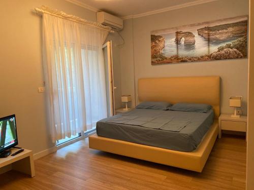 a bedroom with a bed and a flat screen tv at Apartment in Primavera Residence in Fushë-Draç