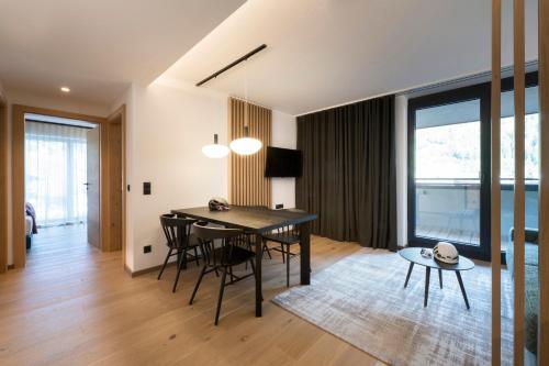 a dining room and living room with a table and chairs at Neueröffnung ELVA PREMIUM APARTMENT HOTEL inklusive Sommerpass STUBAI SUPER CARD in Neustift im Stubaital