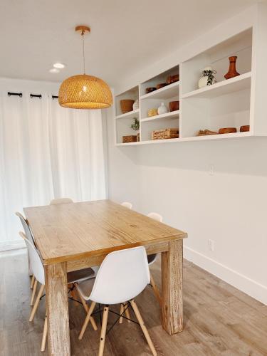 a dining room with a wooden table and white chairs at Hale Moana Retreat AC Walk to Ocean and Spacious Family Stay in Laie