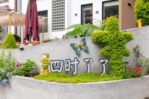a garden with a little girl and a butterfly on a sign at 四时了了民宿 in Zhangjiajie