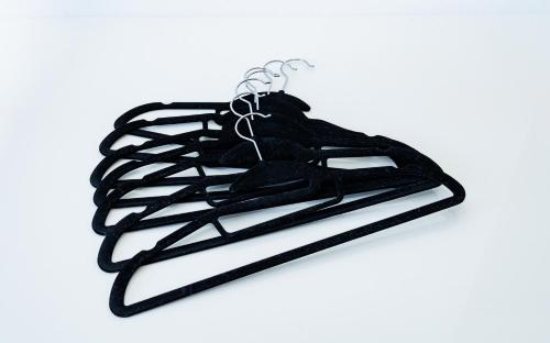 a rack of black hangers on a white background at Cruise Inn Kameari in Tokyo