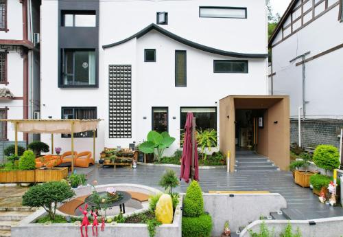 a house with a courtyard in front of it at 四时了了民宿 in Zhangjiajie