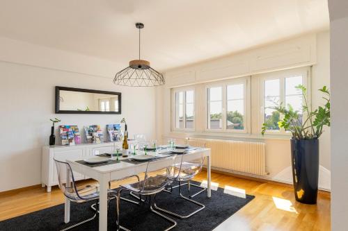 une salle à manger avec une table et des chaises blanches dans l'établissement Bel appartement centre climatisé parking privé, à Colmar