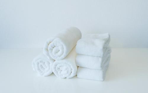 a pile of white towels on a white background at Cruise Inn Kameari in Tokyo