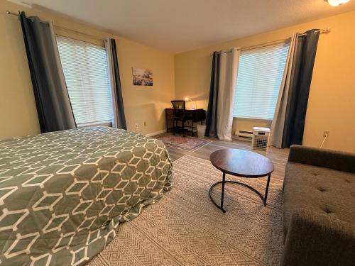 a bedroom with a bed and a table and a couch at Private Room "Apple" by UW in Seattle