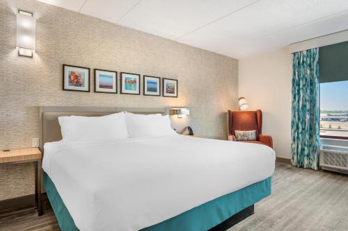 a hotel room with a large bed and a chair at Hilton Garden Inn Wisconsin Dells in Wisconsin Dells