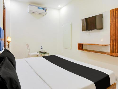 a bedroom with a bed and a tv on the wall at Hotel O Holiday First in Amritsar