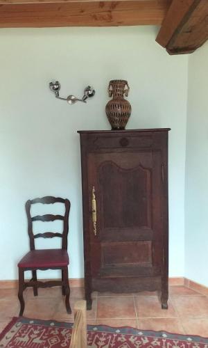 a chair and a vase on a wall next to a door at Quiet spacious cottage in Marnefer
